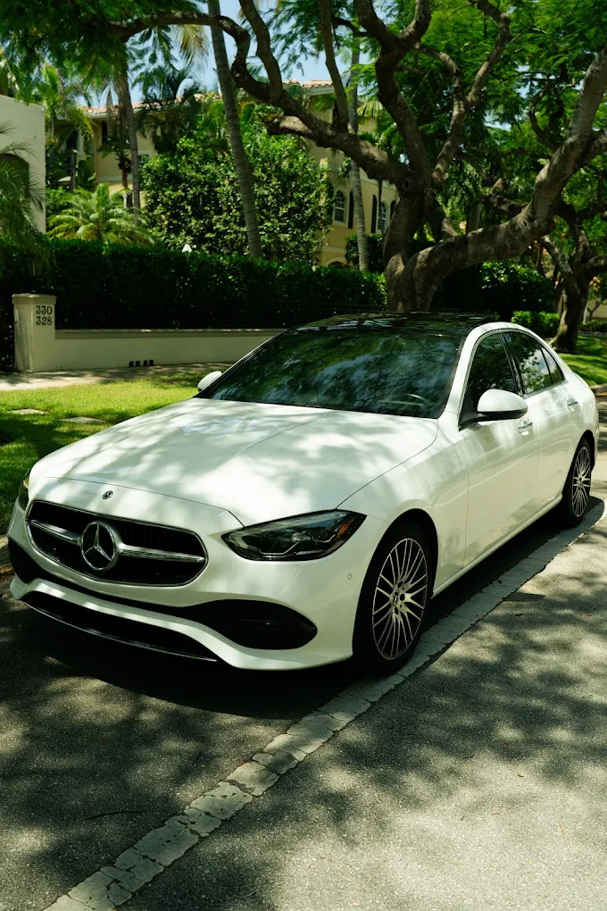 White Mercedes-Benz C300 on a tree-lined street